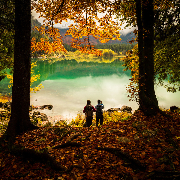 two girls walking in the forest in the italian alps